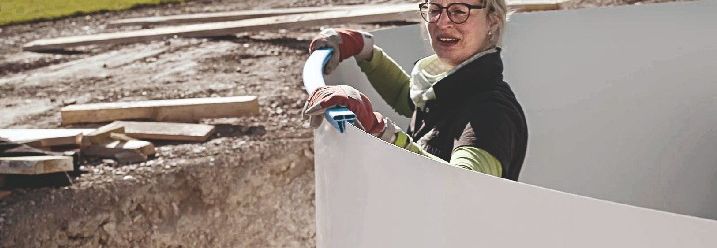 Handwerkerin stellt einen Stahlwandpool auf.